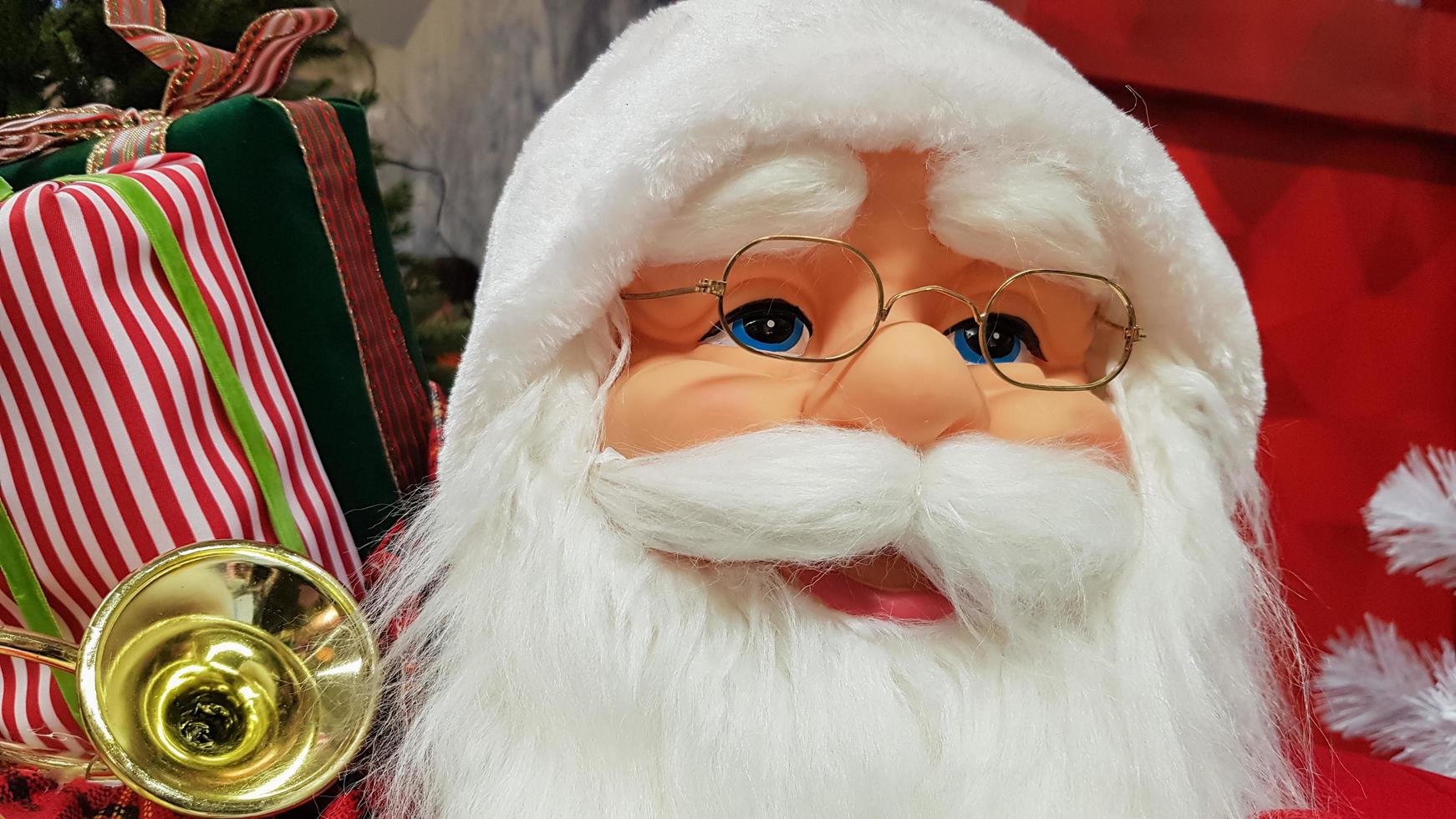 fotoporträtt av en glad leksaksdocka jultomten med en påse med presenter symboliserar julens och det nya året. festlig stämning, semester koncept. foto