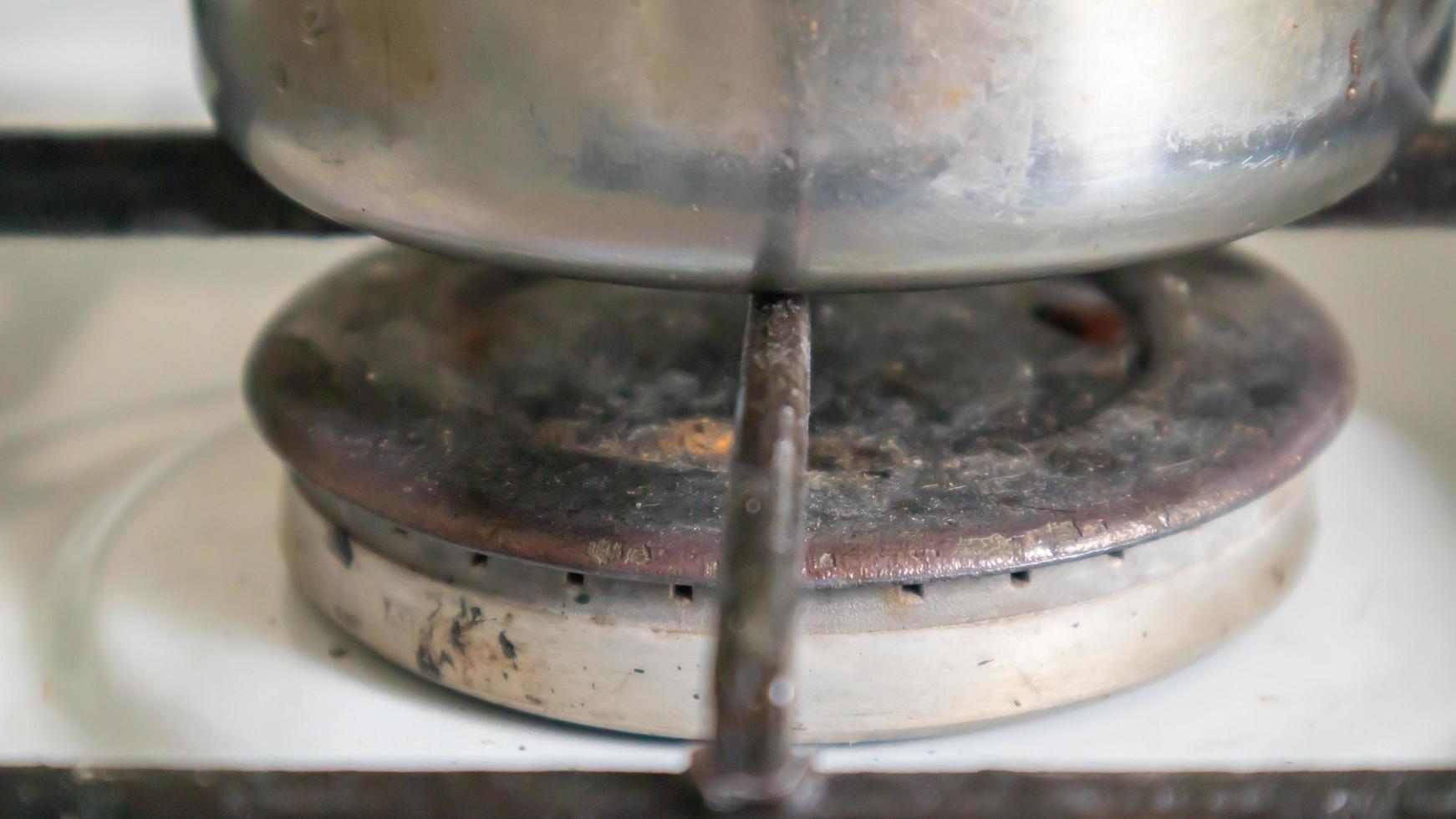 smutsig gasspis i köket för matlagning med vegetabiliska oljefläckar och brända matrester på ytan, närbild. selektiv fokusering. fettklädd gasspis i köket. foto