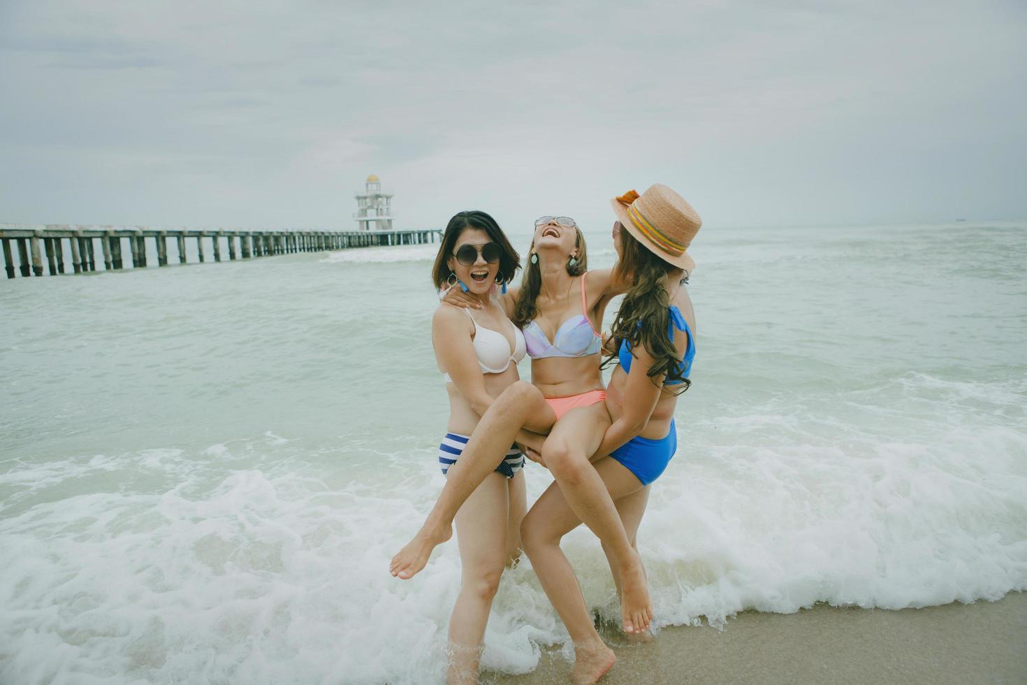 tre bikini asiatisk kvinna lycka med avkopplande känslor i semester havet strand foto