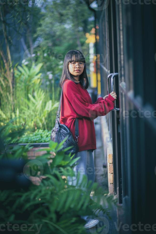 asiatisk tonåring står mot stäng dörr foto