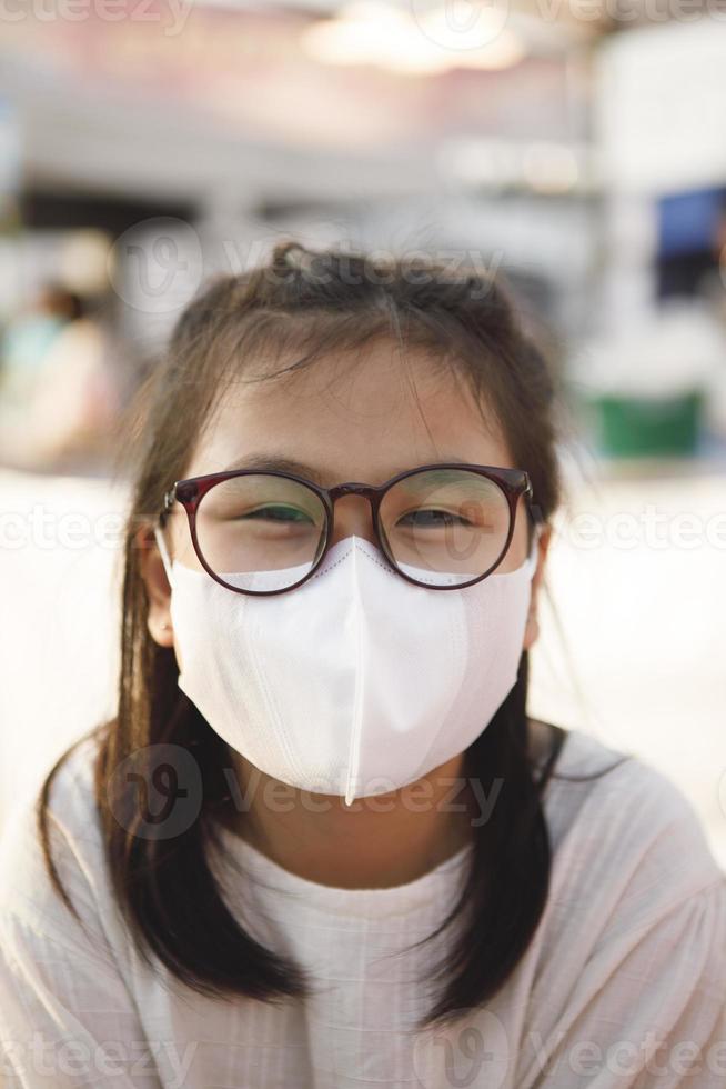närbild asiatisk flicka bär skydd ansiktsmask foto