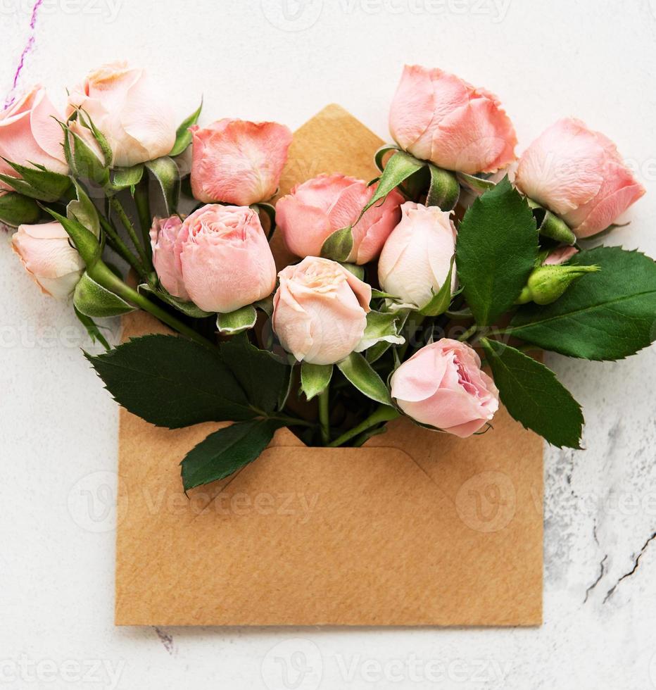 kuvert och rosa rosor foto