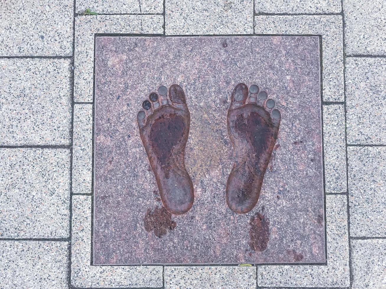 två dekorativa fotspår på gatstensplatta foto