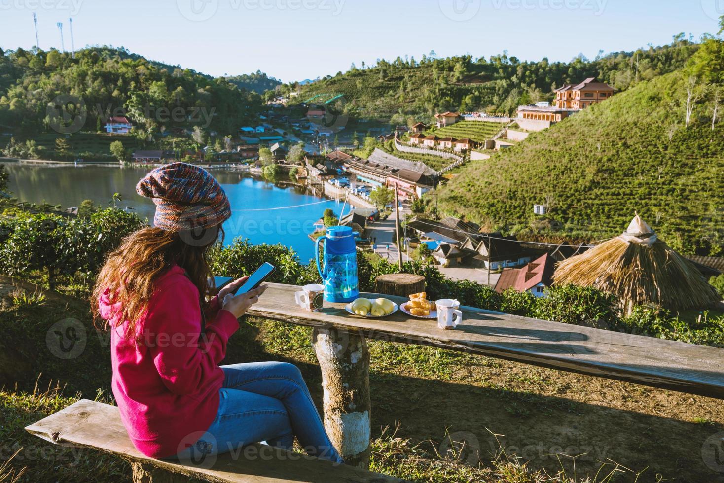 flickan reser på berget. hon tittar på det vackra landskapet i ban rak thai village, dricker kaffe och äter mat, mellanmål på morgonen. foto