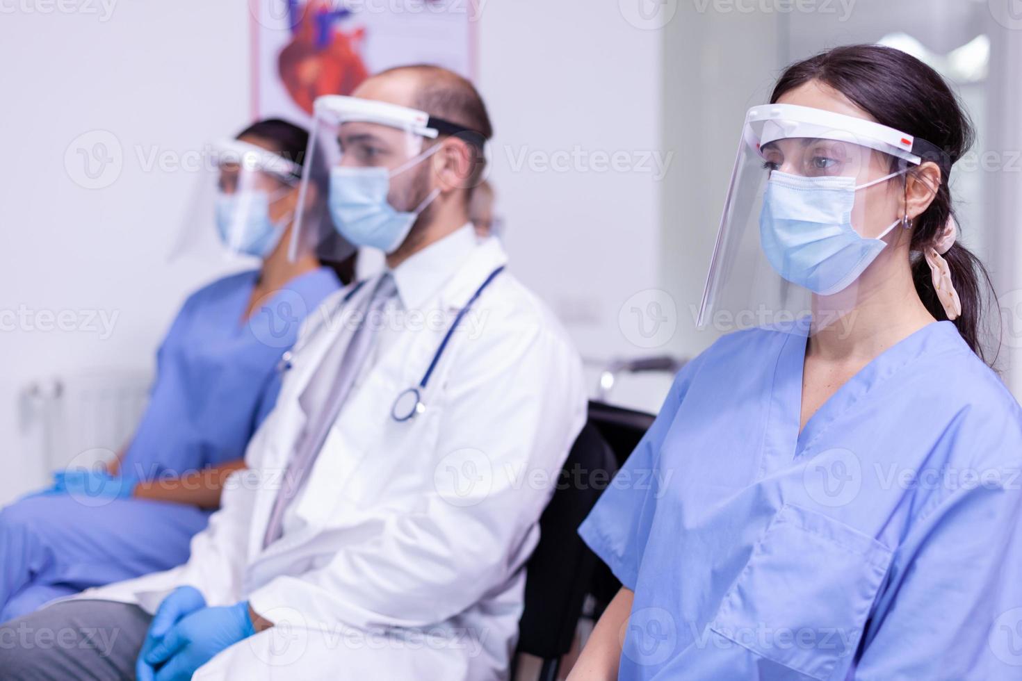 medicinsk personal i uniform och skyddsmask tittar på kameran foto