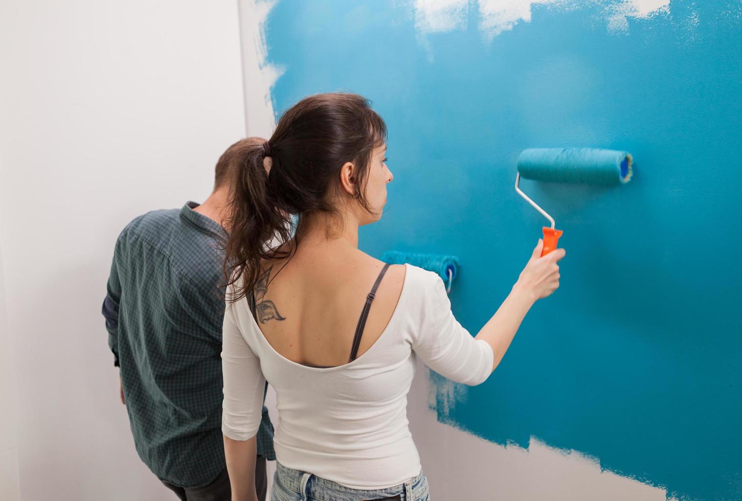 kvinna måla väggen foto