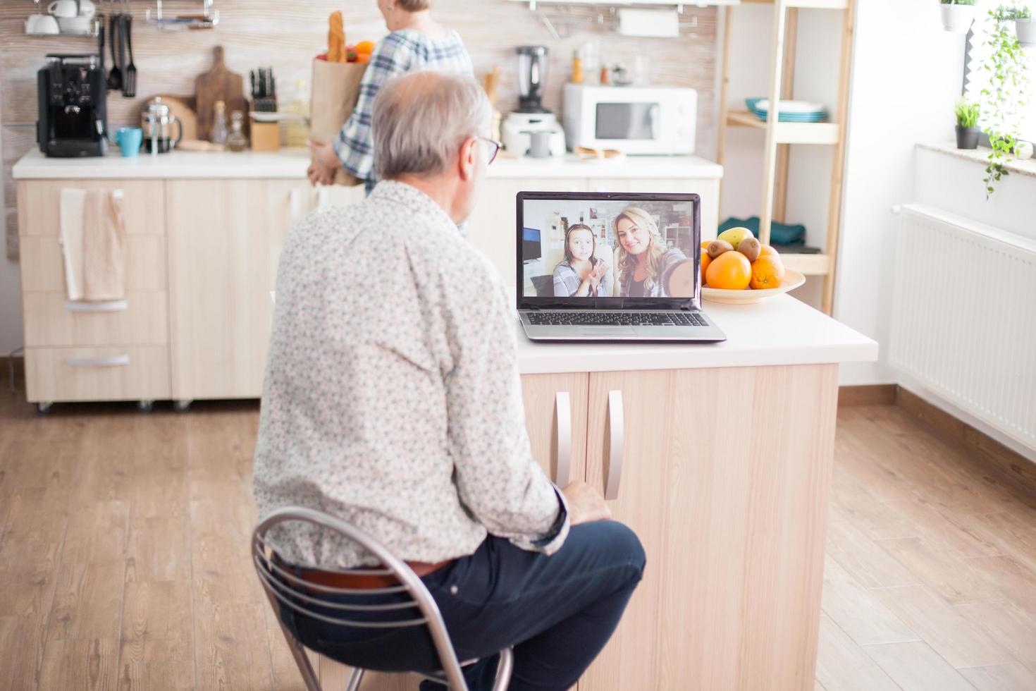 senior man pratar med systerdotter på videosamtal foto