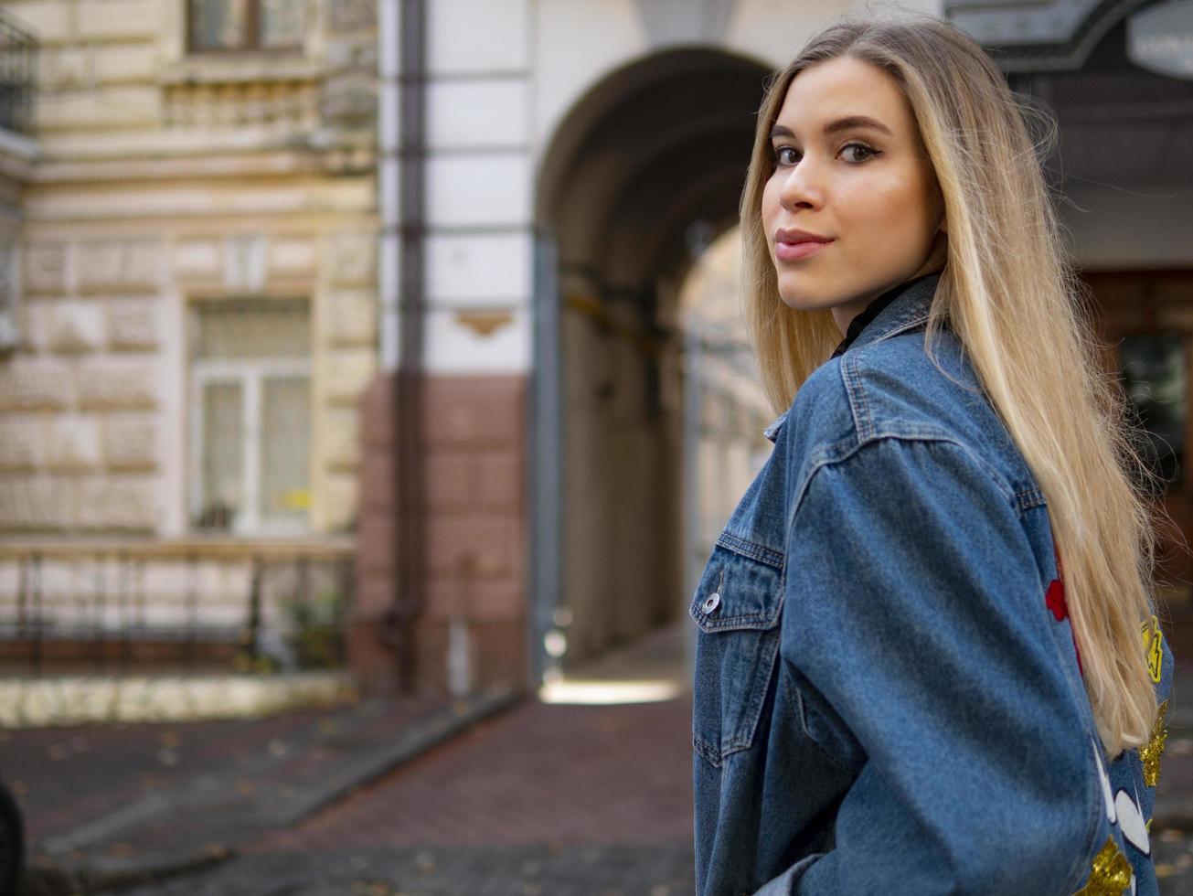 flicka med flödande hår i en jeansjacka foto