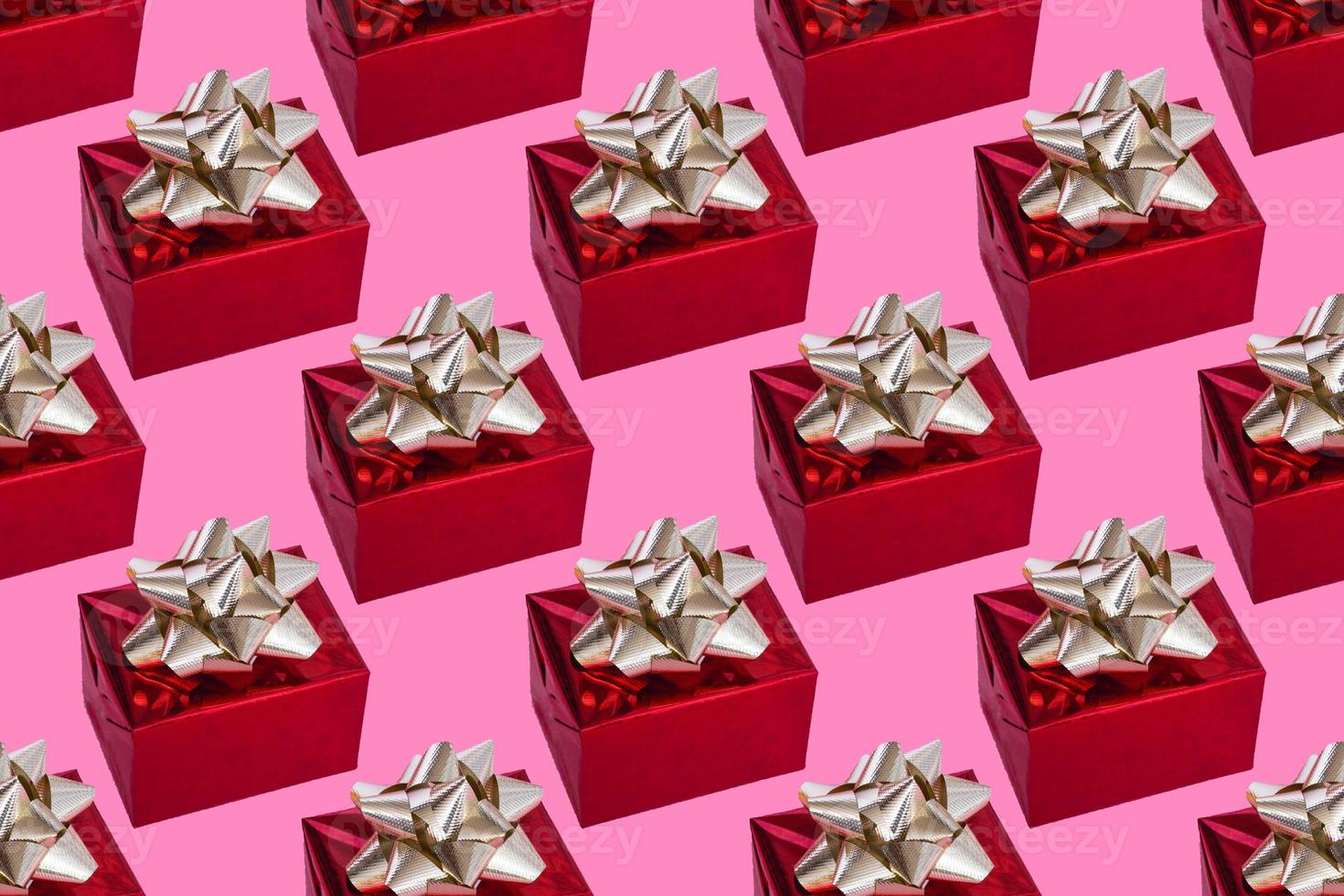 annandag jul. julkomposition. röd present med en guldrosett på en rosa bakgrund. mönster. foto