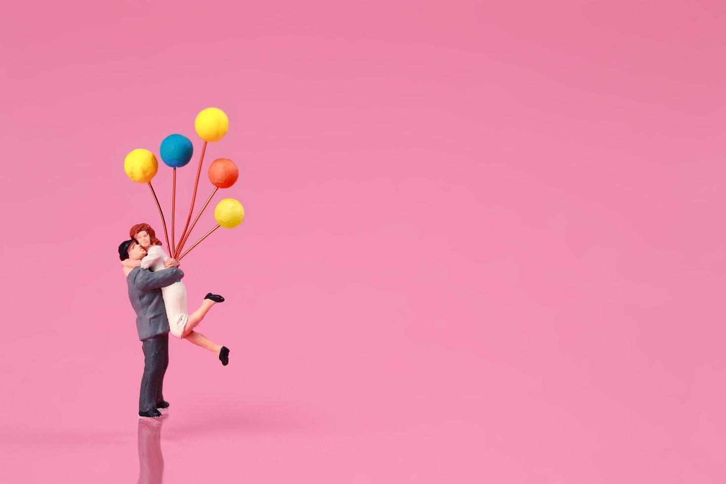 ett par står och håller ballong på rosa bakgrund idé för kärlek koncept foto
