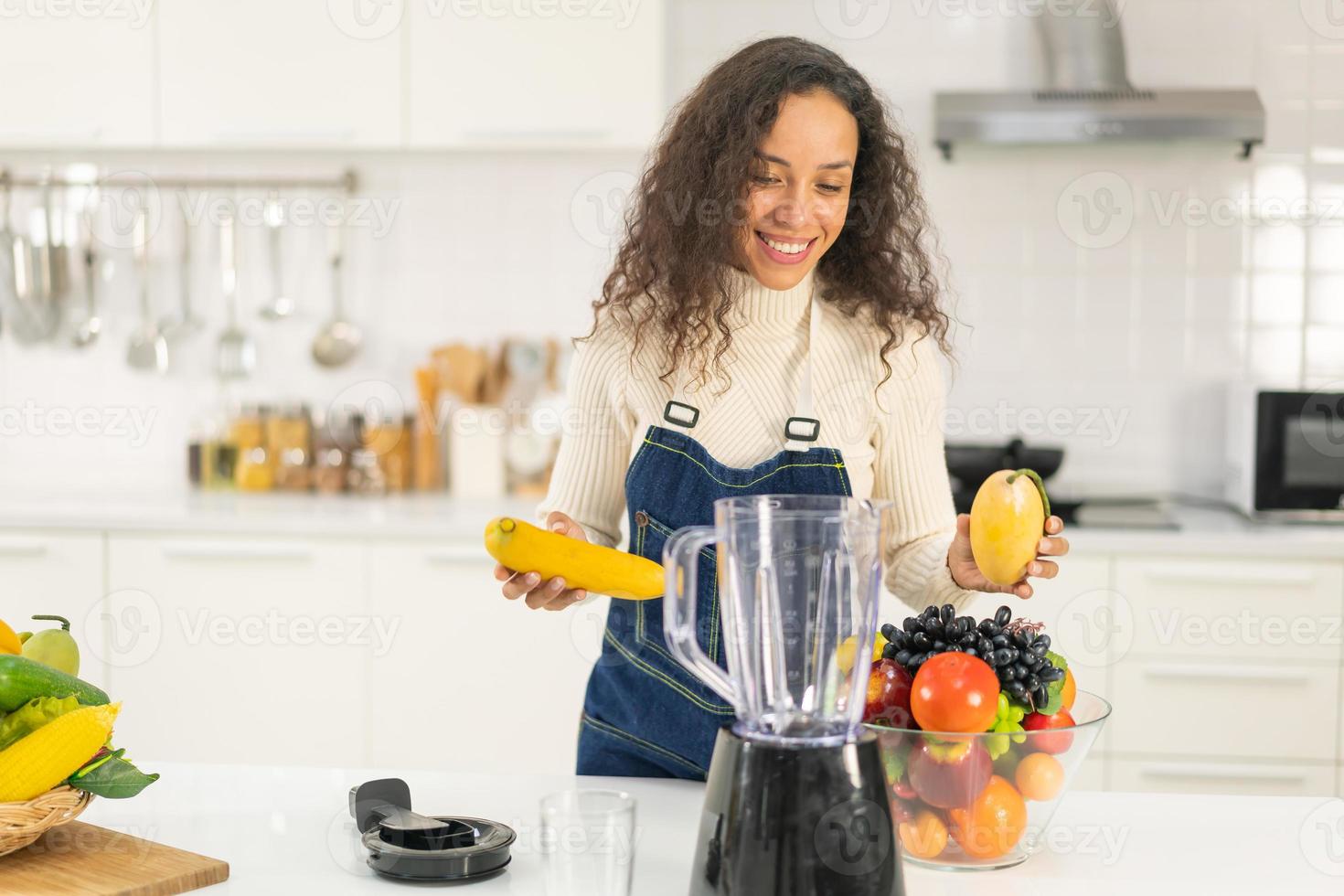 latinsk kvinna som gör juice i köket foto