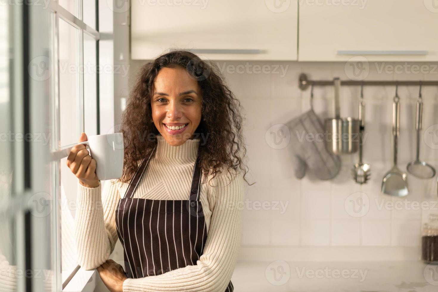 latinsk kvinna dricker kaffe i köket foto