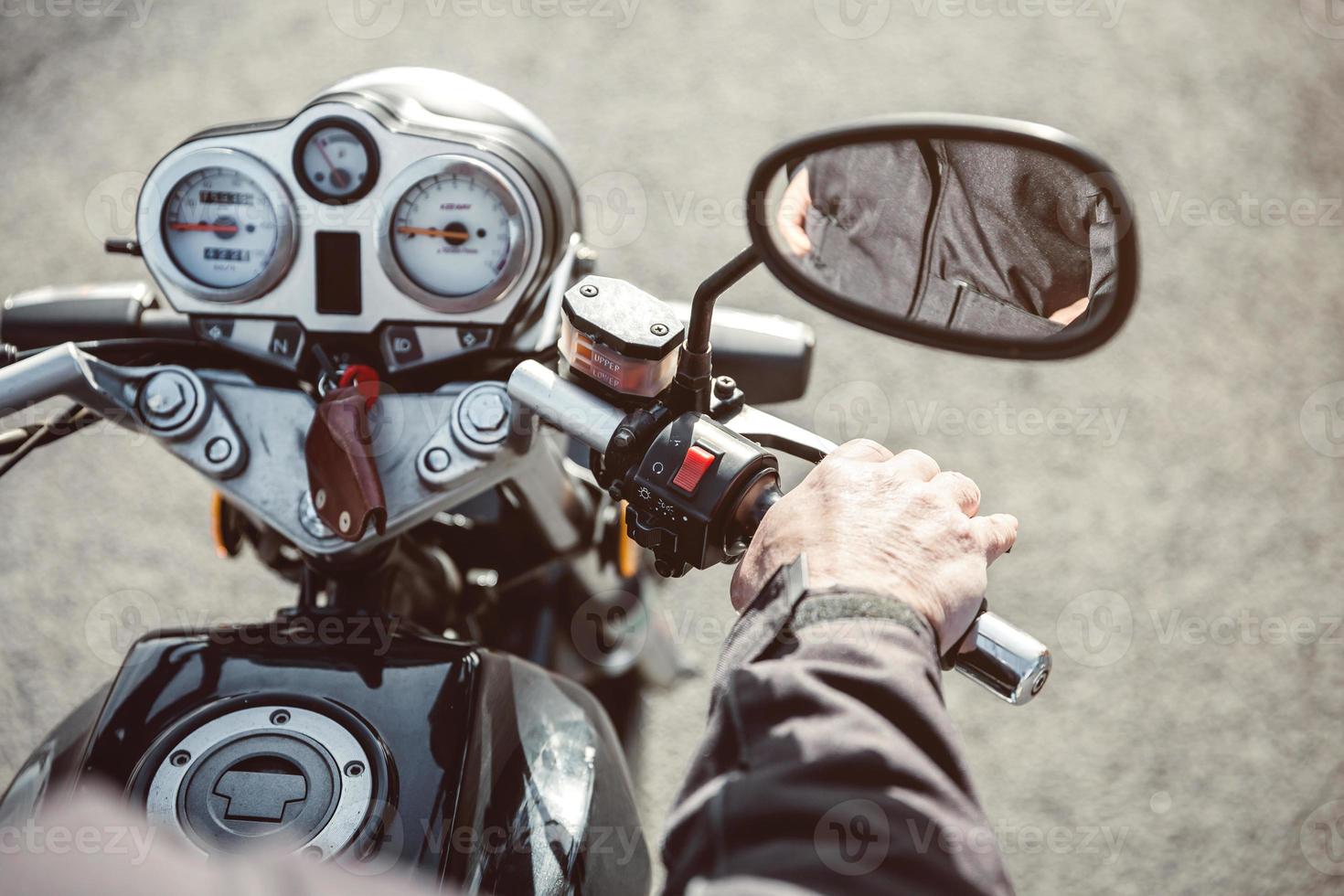 senior man handstyrning motorcykel på väg foto