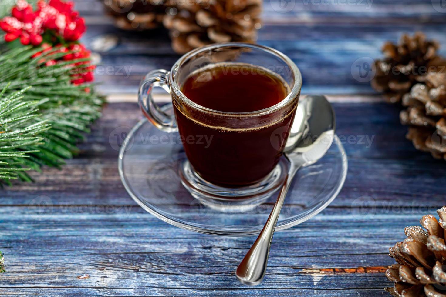 en kopp aromatiskt kaffe med farinsocker, juldekorationer, grenar av en julgran. semester koncept nytt år. på en trä bakgrund. foto