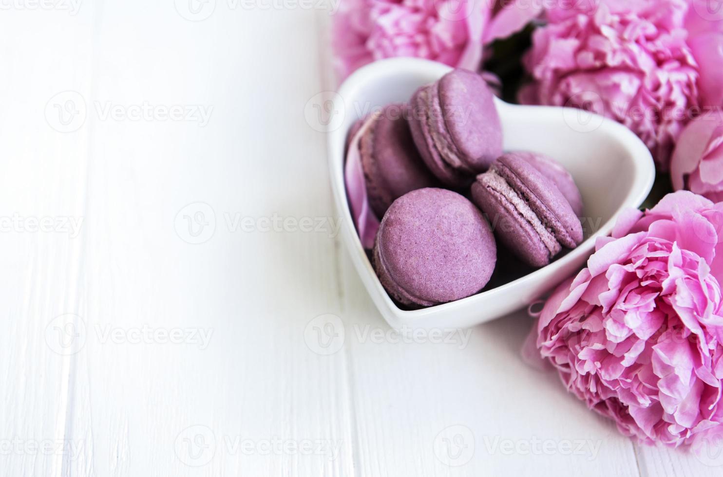 rosa pionblommor med macarons foto