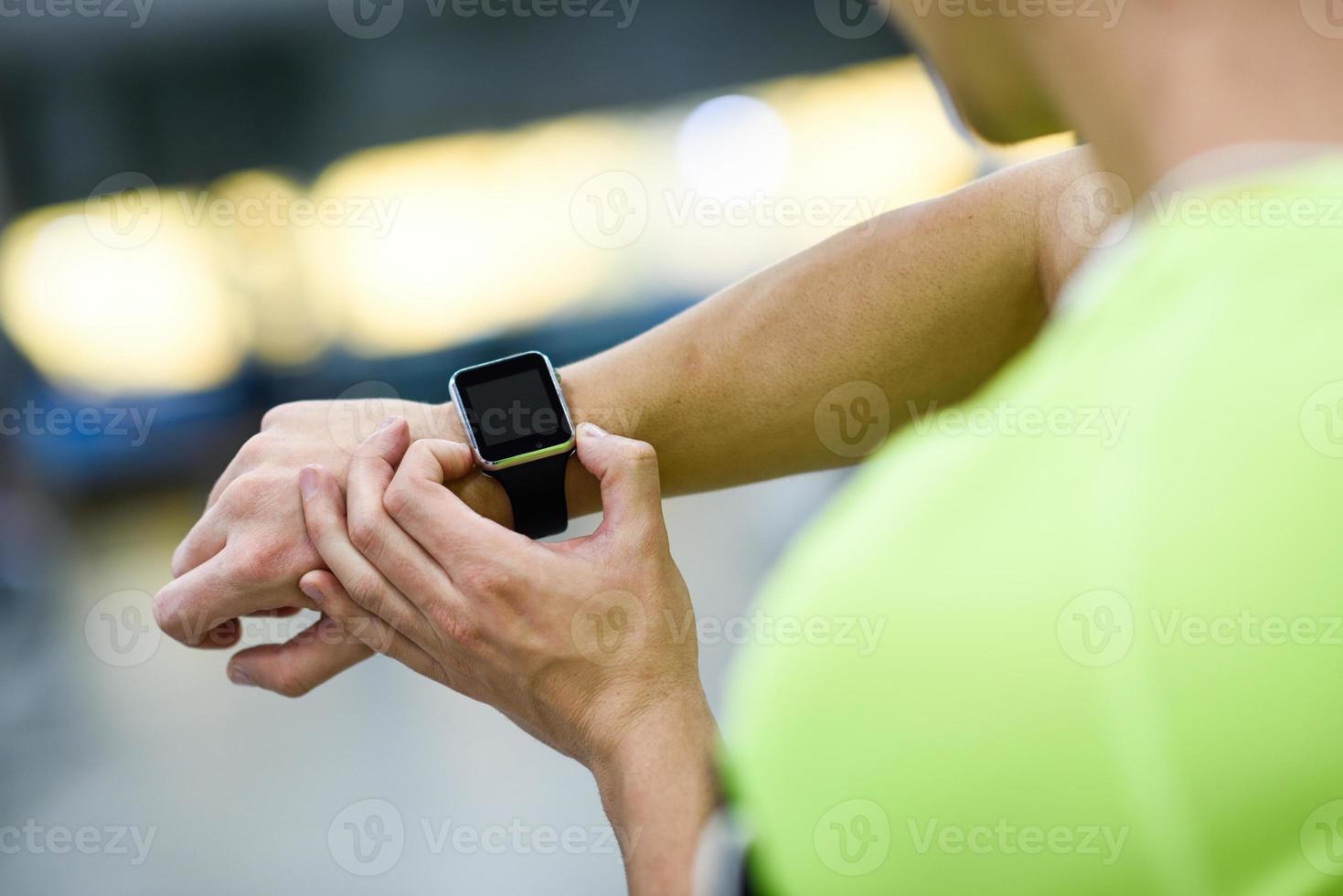 ung man använder smartwatch på gymmet foto
