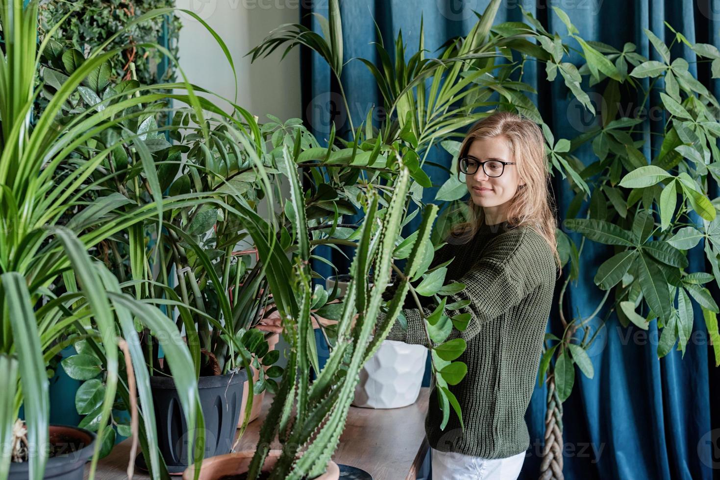 ung kvinna som tar hand om växterna hemma foto
