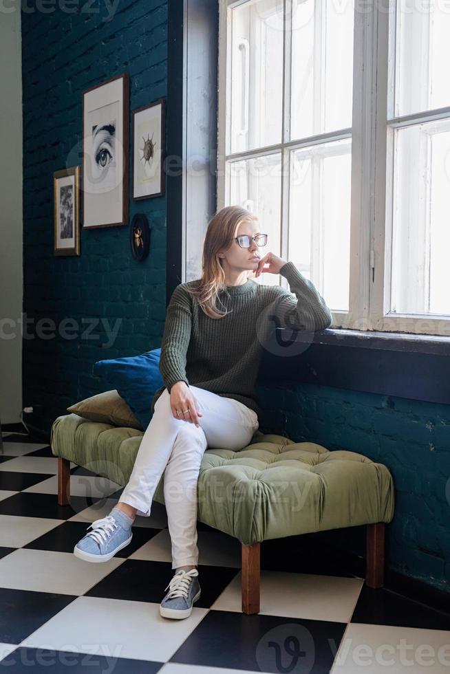 ung kvinna sitter i elegant vardagsrum foto