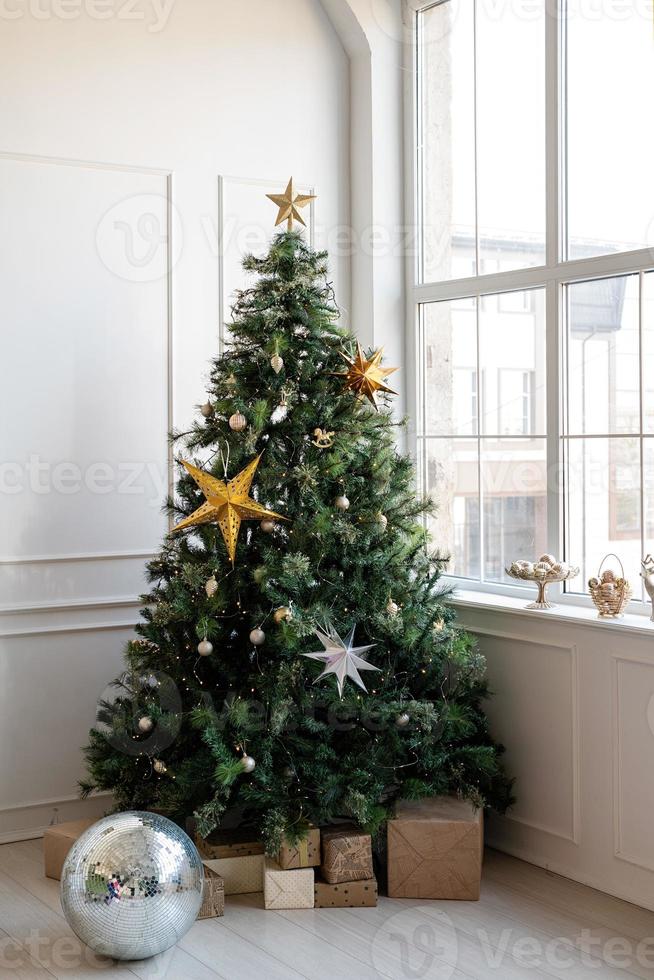 julgran med presenter och ljus i ljust och luftigt vardagsrum foto