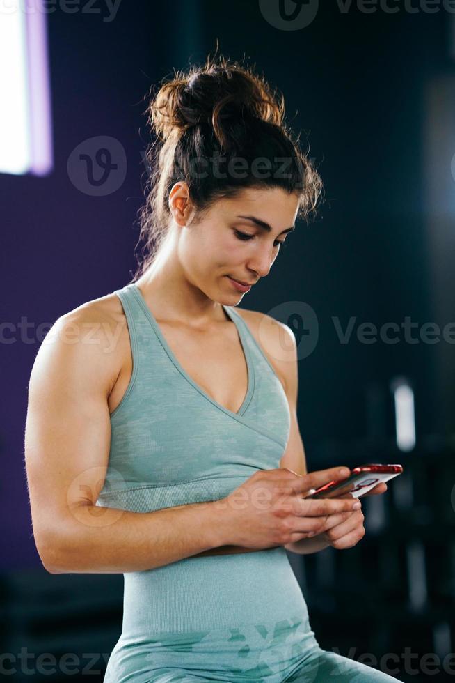 kvinna konsulterar sin utbildning på sin smartphone sitter i en hopplåda foto