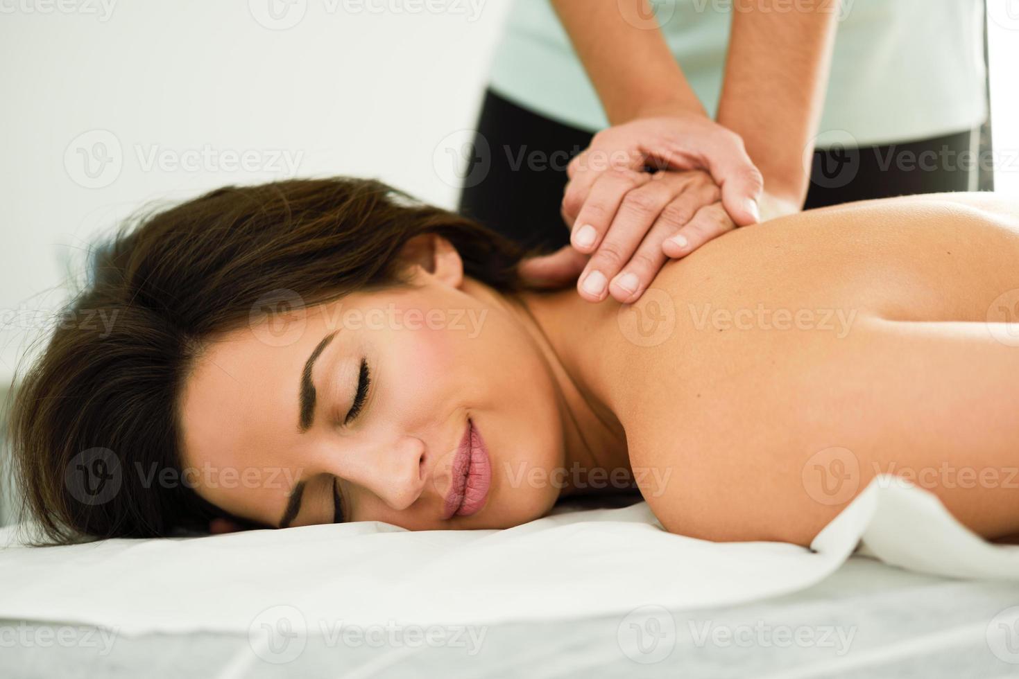 ung kvinna som får en ryggmassage i ett spacenter. foto