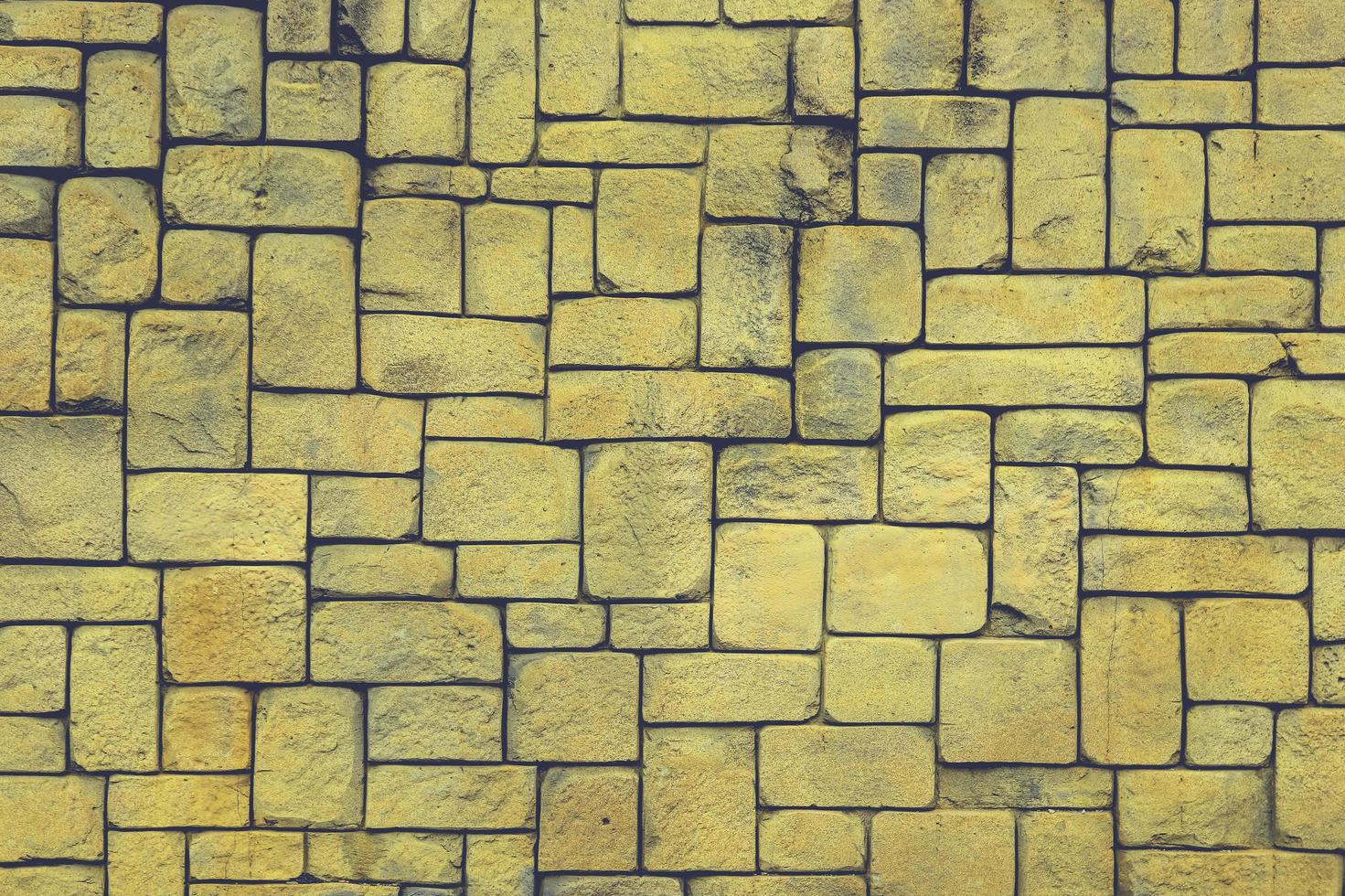 abstrakt gul stenmur realistisk textur prydnad bygga rock på naturmönster ljus. foto