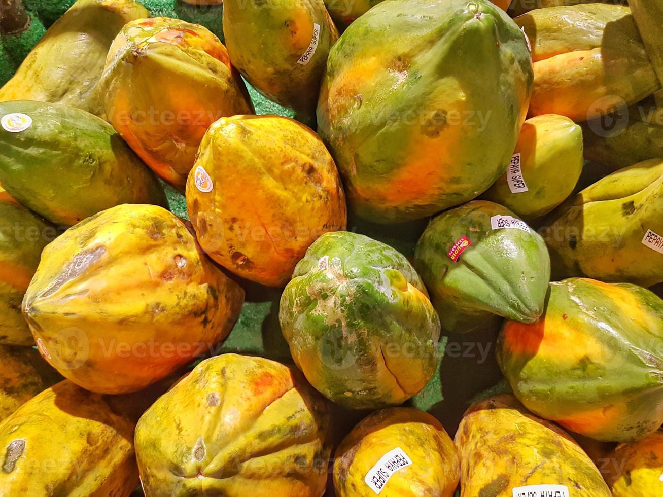 papayafrukten är grön och gul i en behållare foto