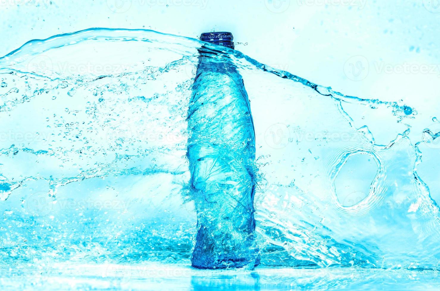 ljusblå transparent vattenvågsyta med stänkbubbla på flaskvatten. foto