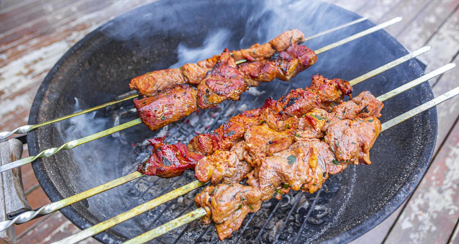 rysk shashlik med spett på en rund grill. foto