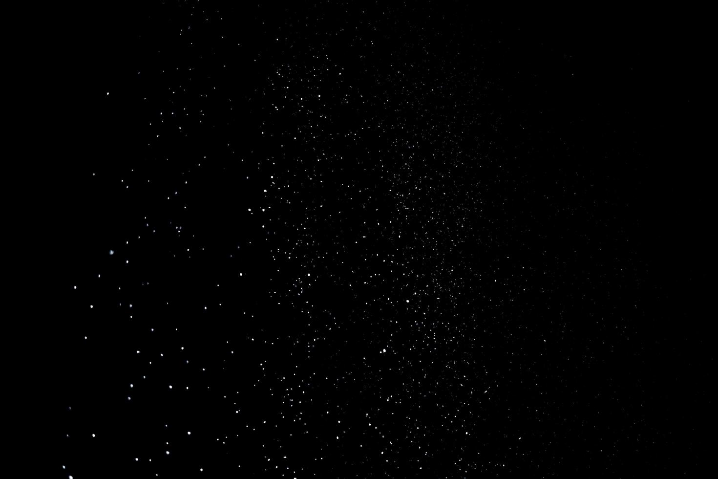 de vita partiklarna på svart bakgrund som representerar ett snöfall. snö överläggsfilmer för att ge en frys- eller vintereffekt till videopresentationen. foto