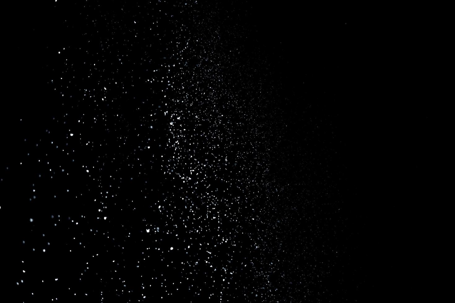 de vita partiklarna på svart bakgrund som representerar ett snöfall. snö överläggsfilmer för att ge en frys- eller vintereffekt till videopresentationen. foto