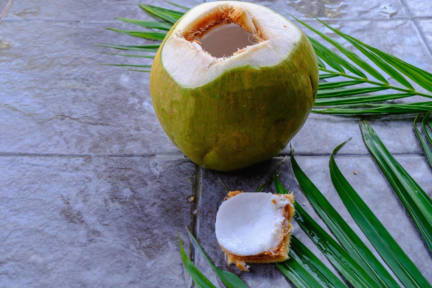 färsk grön kokosfrukt och kokosblad foto