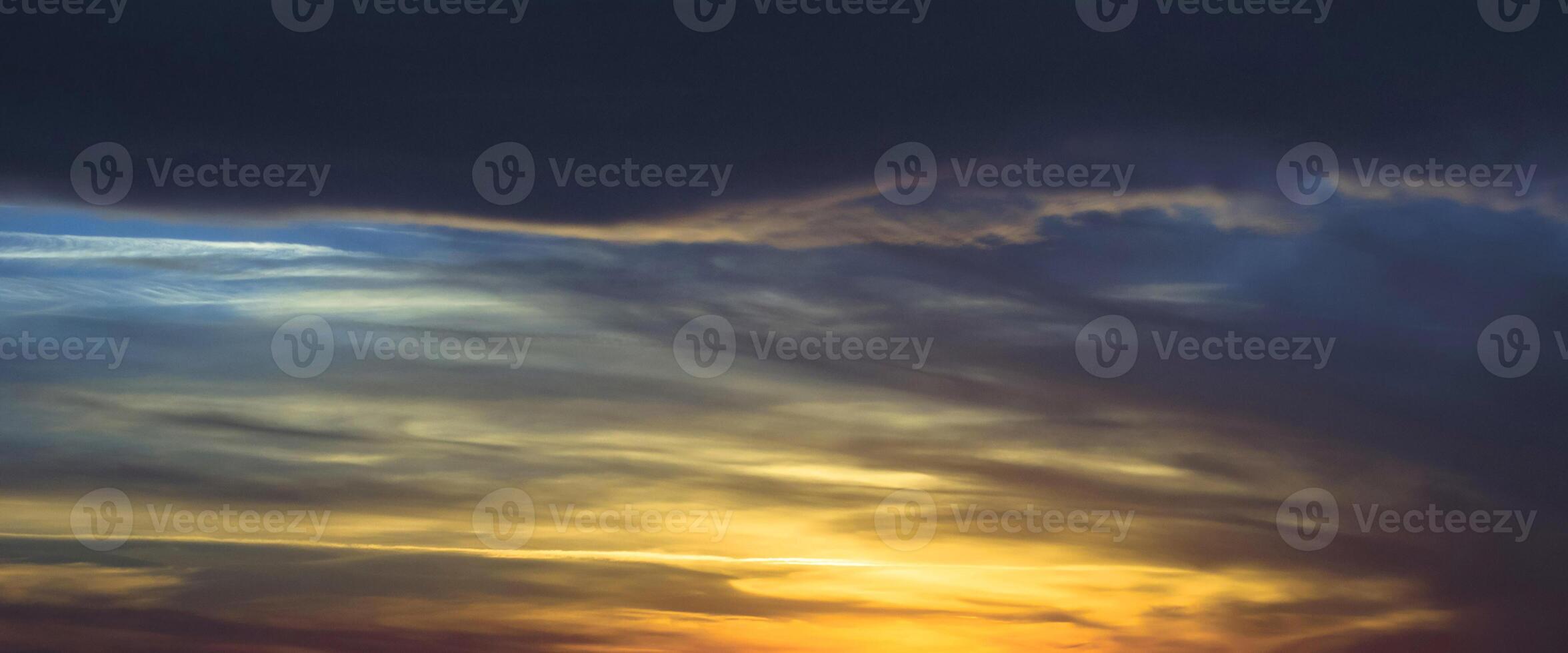 vacker gul och mörkblå himmel kväll skönhet och moln vid solnedgången, gryningen, solens strålar bryter igenom molnen. naturlig foto