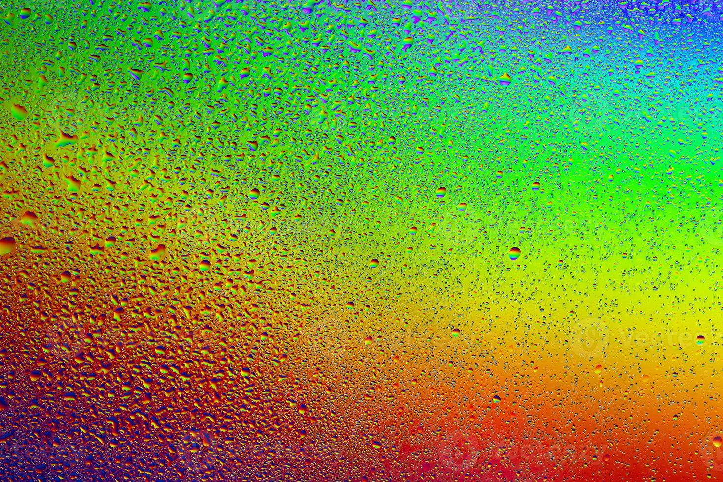 droppar vatten på en regnbåge bakgrund. foto