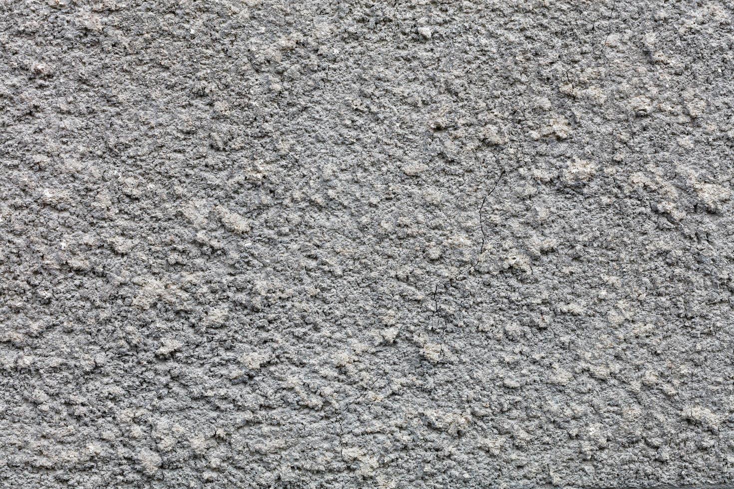 textur och bakgrund av en grå texturerad vägg täckt med en cementrock. foto