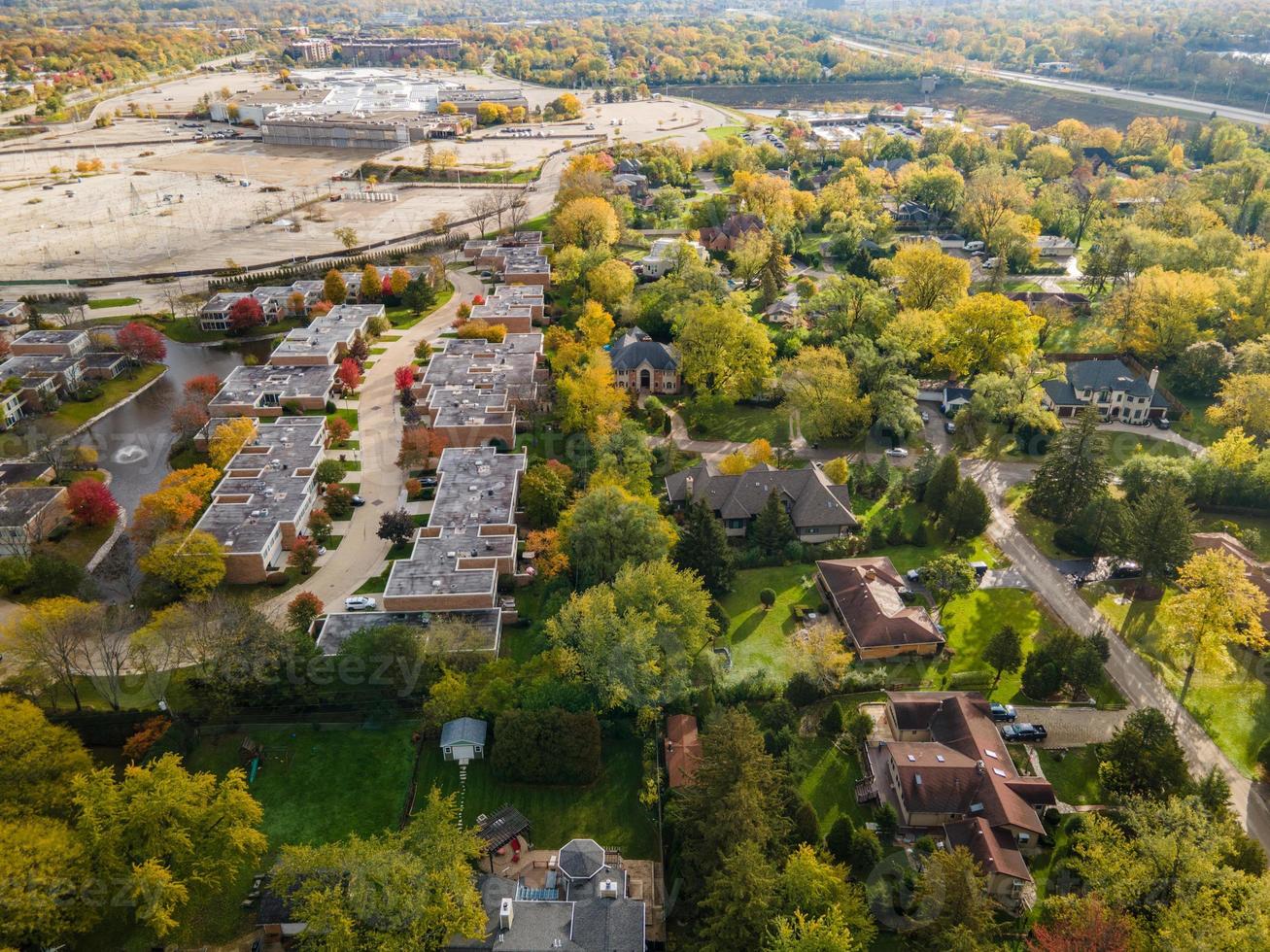 Flygfoto över bostadsområde i Northfield, il. massor av träd börjar få höstfärger. stora bostadshus, några med solpaneler. slingrande gator foto