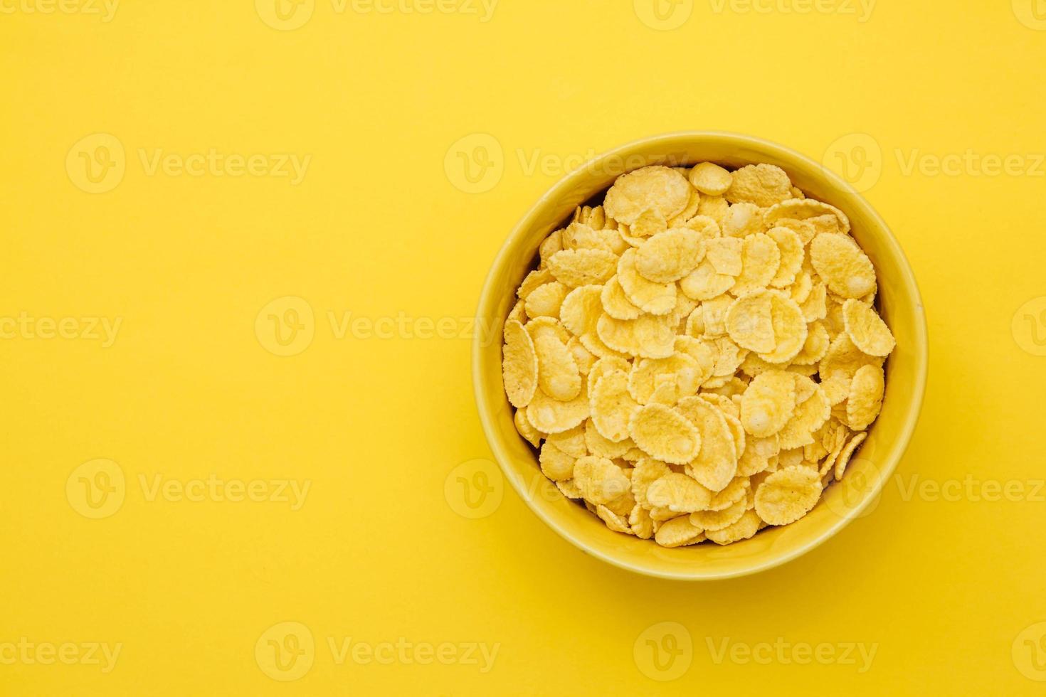 cornflakes i gul skål på gul bakgrund för spannmål hälsosam mat foto