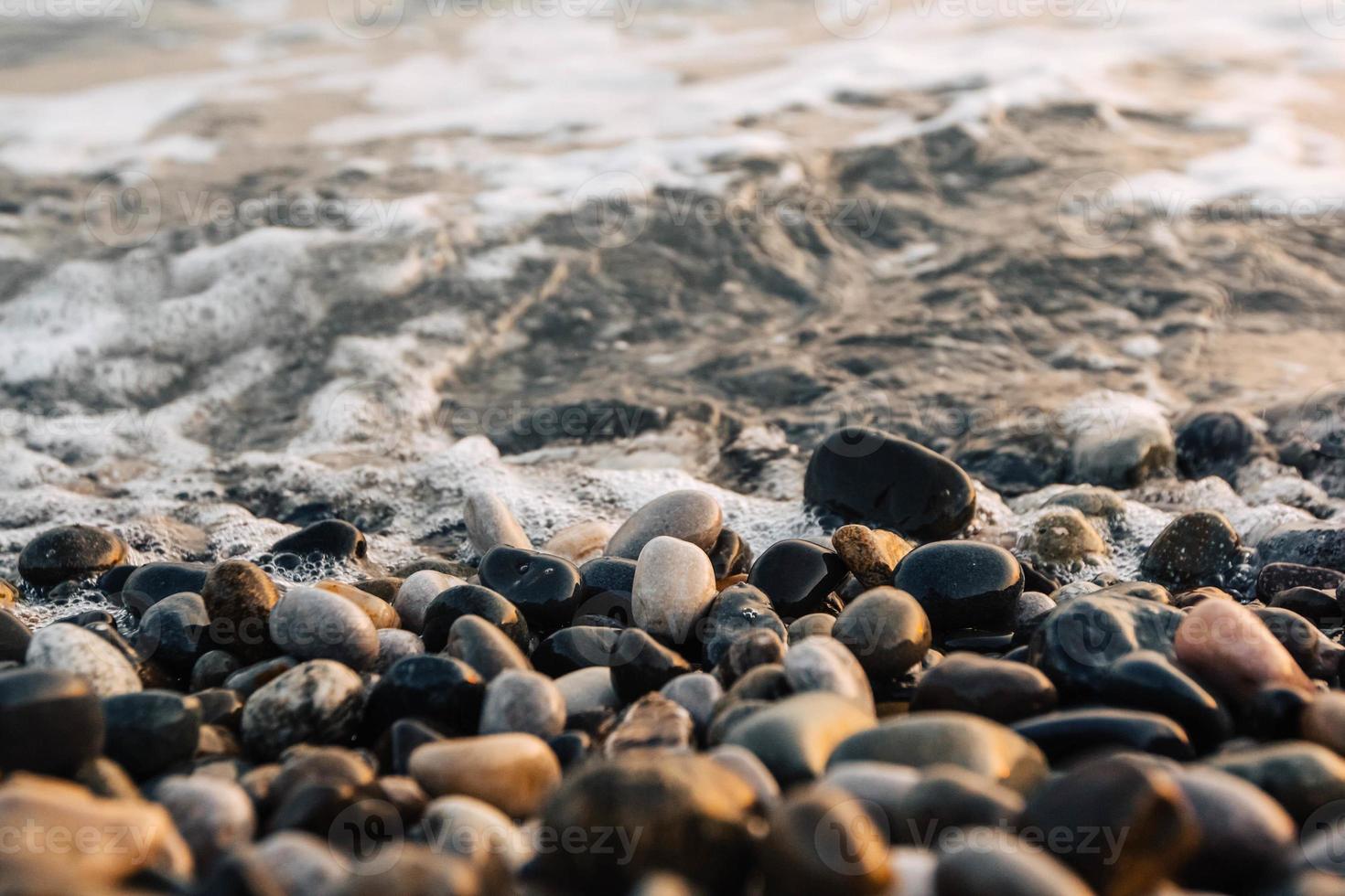 små stenar vid havet med bokeh-effekt foto