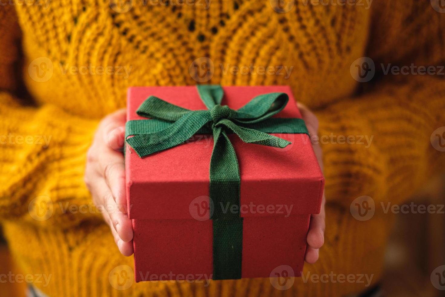 kvinna som håller julen röd present för present att ge på juldagen foto