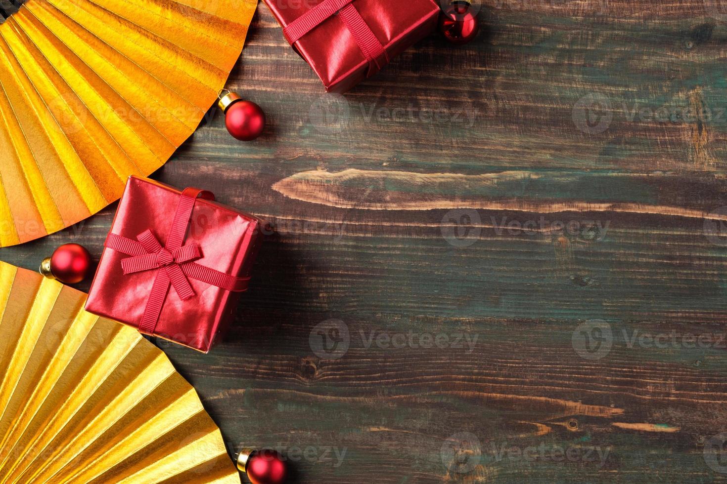 jul röd presentförpackning och gyllene fläkt dekoration på bord trä bakgrund foto