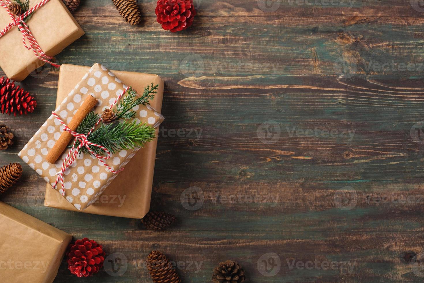 handgjord julklappslåda med brunt pappersdekor med furugran på träbord foto