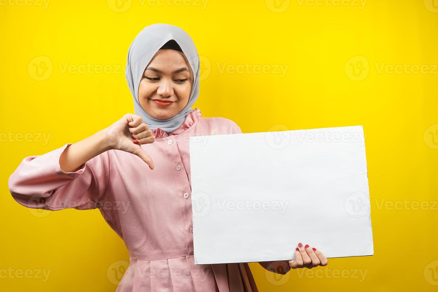 ganska ung muslimsk kvinna ogillar, hand som håller en tom tom banderoll, plakat, vit tavla, tom skylttavla, vit reklamtavla, presentera något i kopieringsutrymmet, marknadsföring foto