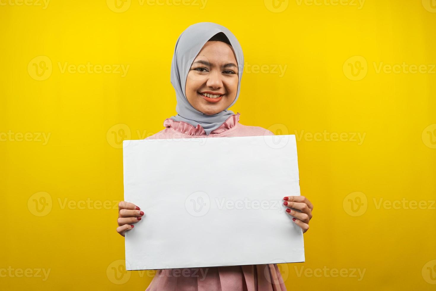 ganska ung muslimsk kvinna gladlynt hållande tom tom banderoll, plakat, vit tavla, tom skylttavla, vit reklamtavla, presentera något i kopia utrymme, marknadsföring foto