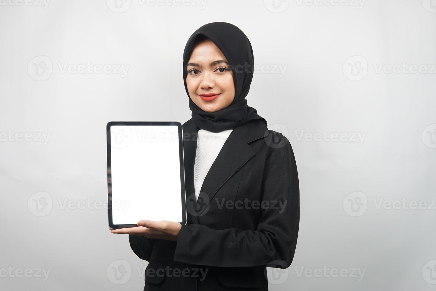vacker ung asiatisk muslimsk affärskvinna självsäker och ler, händer som håller surfplatta med vit skärm eller tom skärm, presenterar något, presenterar produkt, presenterar rapport, isolerad foto