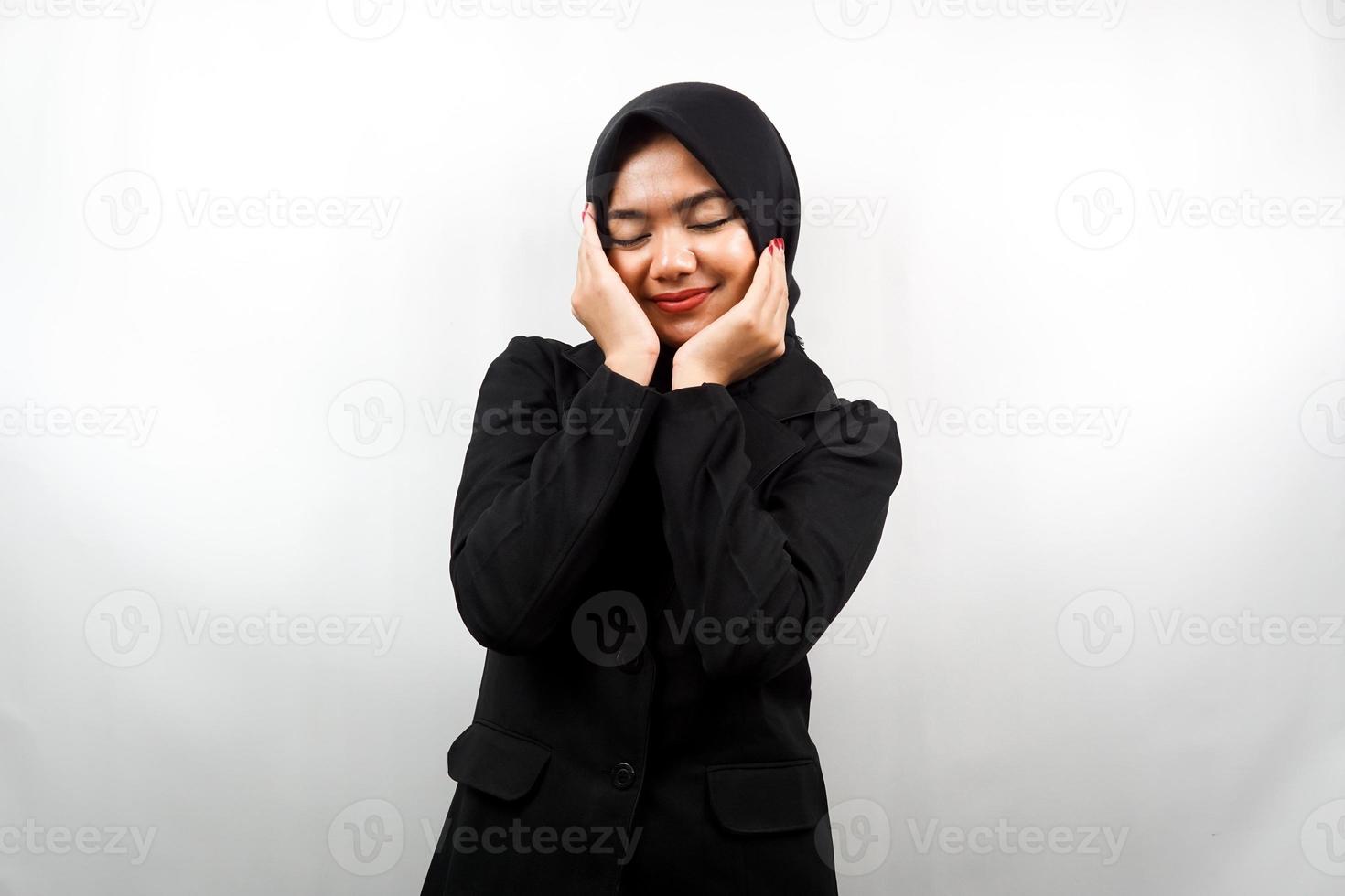 vacker ung asiatisk muslimsk affärskvinna som ler glad, söt, känner sig bekväm, känner sig omhändertagen, mår bra, med händer som håller kinderna isolerad på vit bakgrund foto