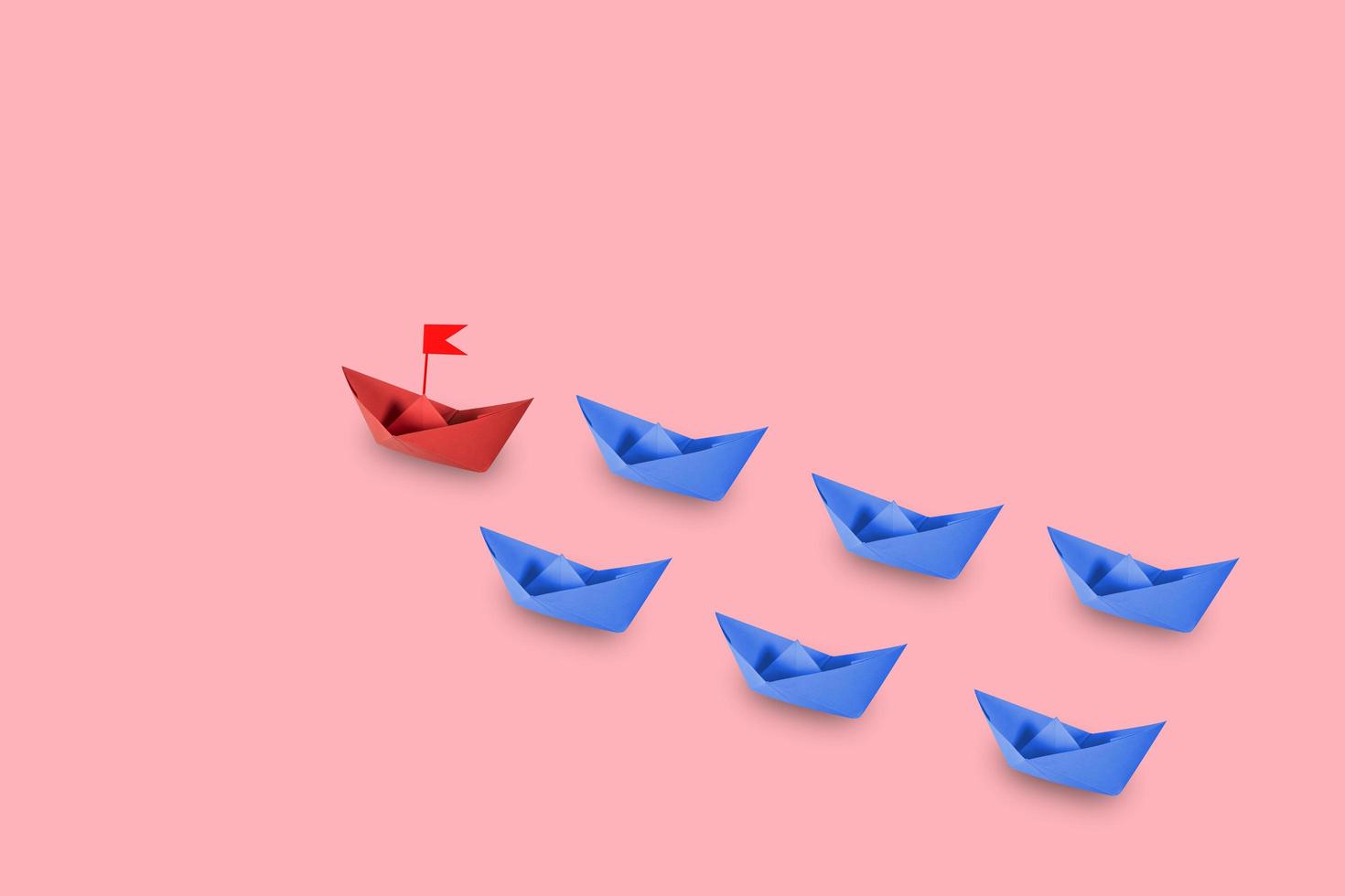 rött papper skepp som leder i pastell bakgrund foto