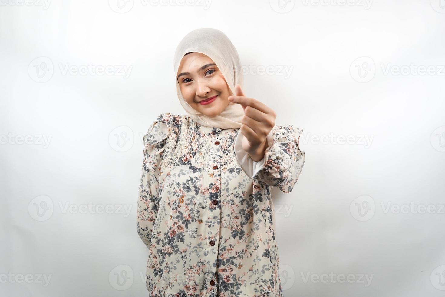 vacker ung asiatisk muslimsk kvinna som ler, med koreansk kärleksteckenhand, hand nära kameran, isolerad på vit bakgrund foto