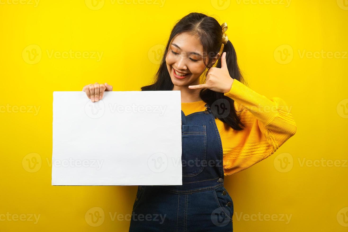 söt och söt ung kvinna gladlynt hållande tom tom banderoll, plakat, vit tavla, tom skylttavla, vit reklamtavla, presentera något i kopieringsutrymme, marknadsföring foto