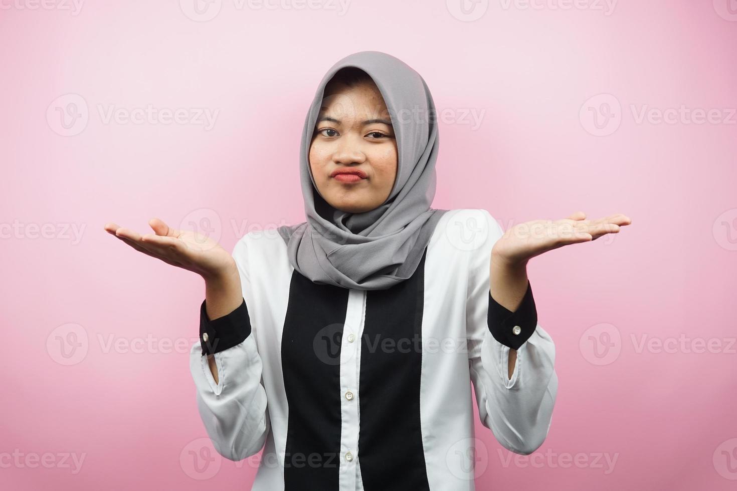 vacker asiatisk ung muslimsk kvinna med jag vet inte tecken uttryck, isolerad på rosa bakgrund foto
