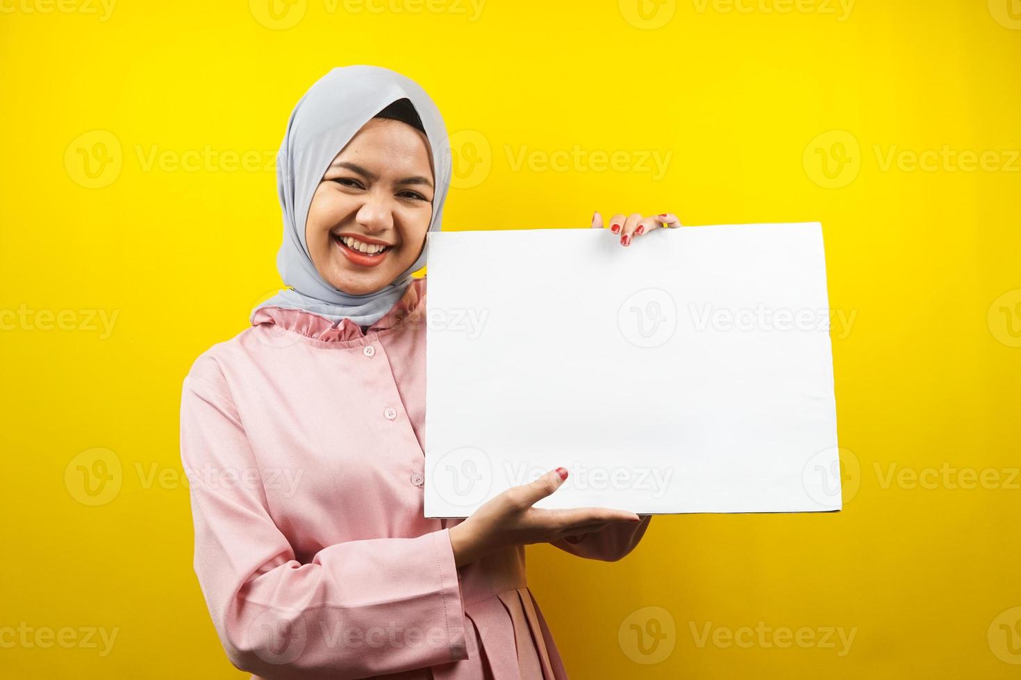 ganska ung muslimsk kvinna gladlynt hållande tom tom banderoll, plakat, vit tavla, tom skylttavla, vit reklamtavla, presentera något i kopia utrymme, marknadsföring foto